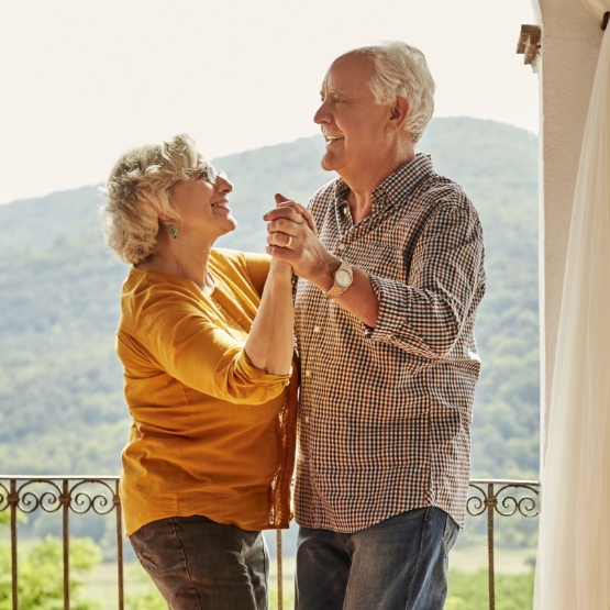 Older couple dancing on balcony